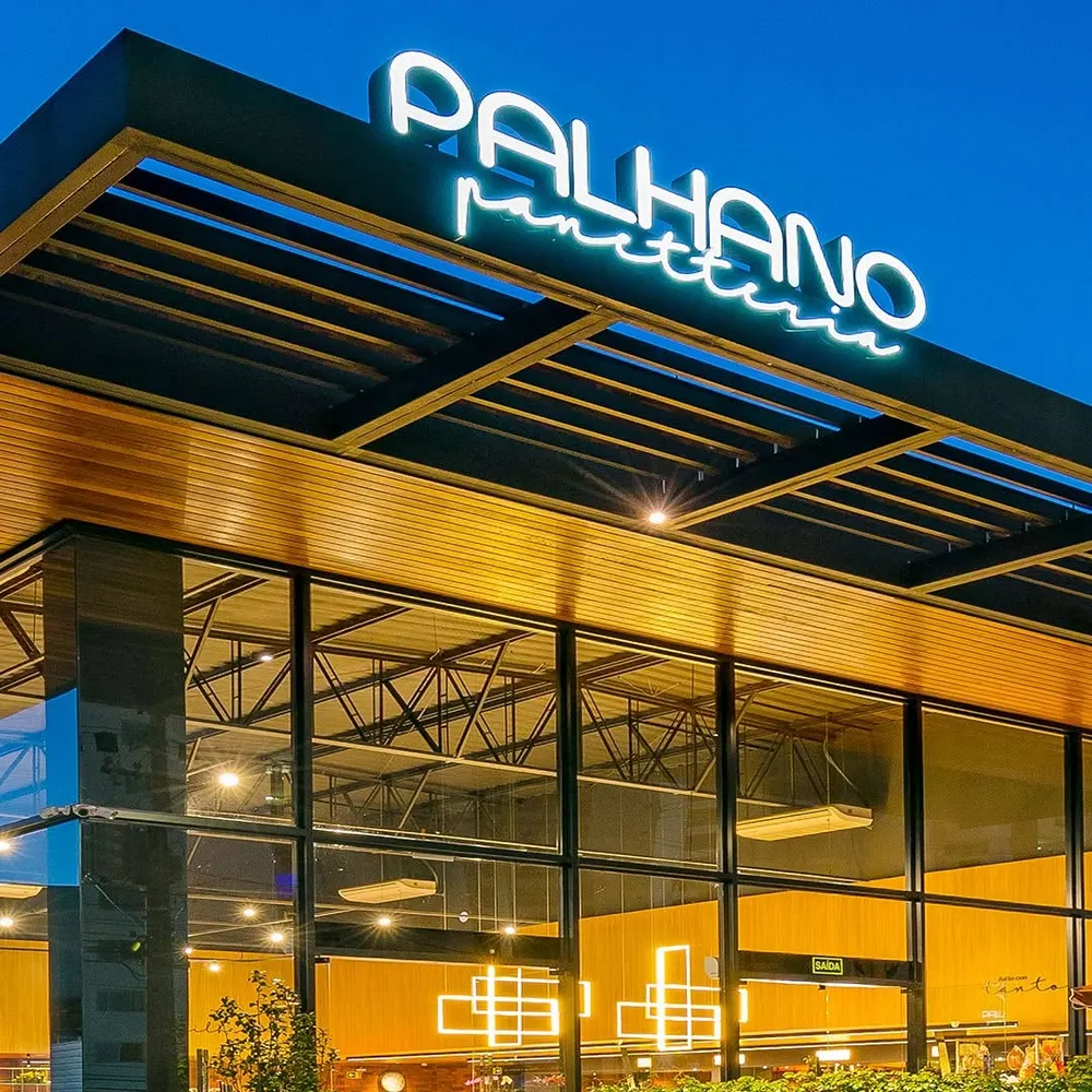 Fachada da Panetteria Palhano à noite, com o letreiro aceso